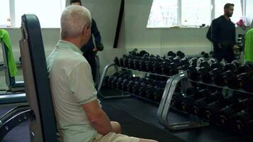 Trainer gives dumbbells to the senior client video