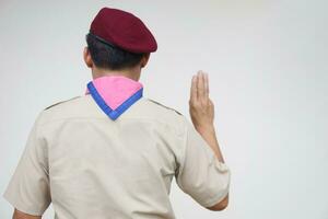 Back view of scout shows hand sign. Concept, Scout activity that teaching in schools Thailand. Hand signs and symbols which meaningful in scouting lesson. Show hand sign for oath. photo