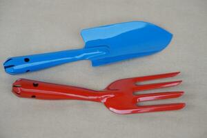 Blue shovel and red digging fork . Concept, gardening tools. Prepare equipment to planting or seeding in agriculture works. photo