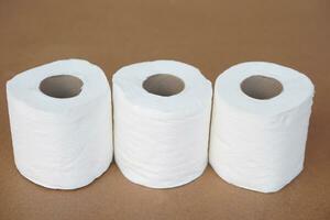 Rolls of white toilet paper, on brown background. Concept, cleaning tool, hygienic to wipe dirty and absorb wet ,use tissue paper for hygienic and sanitary in daily life. photo