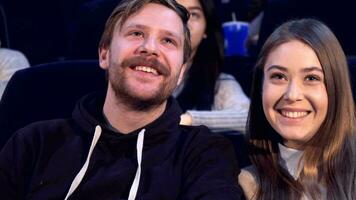 Couple looks at each other at the movie theater video