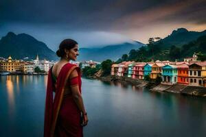 a woman in a sari stands by the water in front of a town. AI-Generated photo
