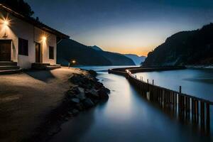 un casa se sienta en el apuntalar de un lago a puesta de sol. generado por ai foto