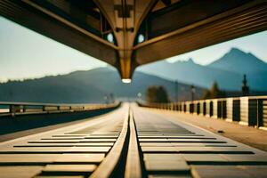 a train track going under a bridge with mountains in the background. AI-Generated photo