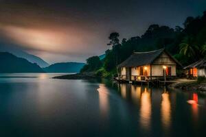 a small house sits on the shore of a lake at night. AI-Generated photo