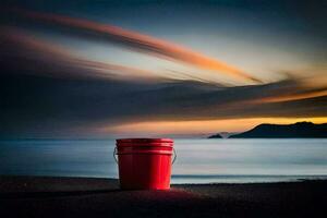 a red bucket sitting on the beach at sunset. AI-Generated photo