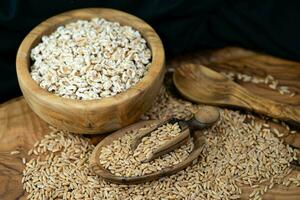 a pile of spelt Triticum aestivum spelta on olive wood photo