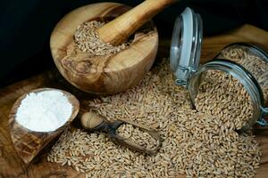 a pile of spelt Triticum aestivum spelta on olive wood photo