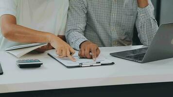 multietnico gruppo di contento attività commerciale persone Lavorando insieme, incontro e di brainstorming nel ufficio utilizzando computer, computer portatile, tavoletta, e mobile Telefono. video