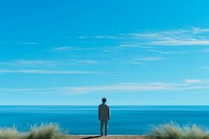 Desolate individual gazing out to sea isolated on a blue gradient background photo