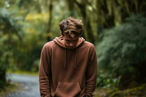 Distraught young adult in serene woodland background with empty space for text photo