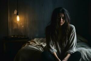 Depressed young woman in dimly lit room background with empty space for text photo