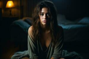 Depressed young woman in dimly lit room background with empty space for text photo