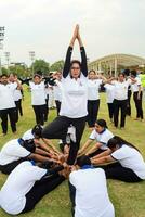 nuevo Delhi, India, junio 21, 2023 - grupo yoga ejercicio sesión para personas a yamuna Deportes complejo en Delhi en internacional yoga día, grande grupo de adultos asistiendo yoga clase en Grillo estadio foto