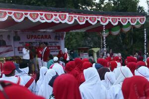 Gorontalo, Indonesia - August 17, 2023 - The Indonesian flag lowering ceremony witnessed by villagers. Indonesia Independence Day photo