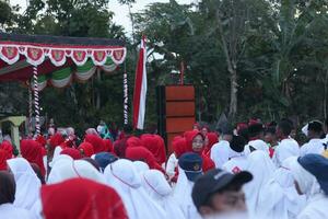 Gorontalo, Indonesia - August 17, 2023 - The Indonesian flag lowering ceremony witnessed by villagers. Indonesia Independence Day photo