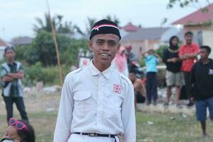 Gorontalo, Indonesia - August 17, 2023 - The Indonesian flag lowering ceremony witnessed by villagers. Indonesia Independence Day photo