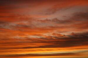 dorado nubes en el noche día con puestas de sol foto