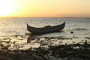 Boat in the lake at sunset. Rowing boat floating over the Limboto Lake waters. Gorontalo, Indonesia photo