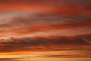 dorado nubes en el noche día con puestas de sol foto