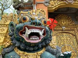 Traditional old ancient Balinese statue of demon angel called barong bali guarding sacred ritual temple photo