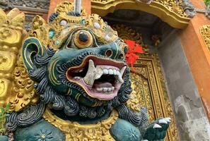 Traditional old ancient Balinese statue of demon angel called barong bali guarding sacred ritual temple photo