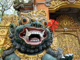 Traditional old ancient Balinese statue of demon angel called barong bali guarding sacred ritual temple photo