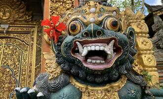 Traditional old ancient Balinese statue of demon angel called barong bali guarding sacred ritual temple photo