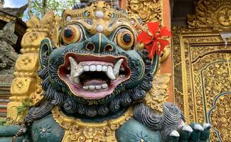 Traditional old ancient Balinese statue of demon angel called barong bali guarding sacred ritual temple photo