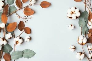 Autumn composition. Frame made of eucalyptus branches, cotton flowers, dried leaves on pastel gray background. Autumn, fall concept. Flat lay, top view, copy space. generative ai. photo