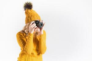 retrato de un hermosa niña fotógrafo en un de punto sombrero quien toma imágenes en el estudio foto