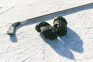 The gloves and hockey stick lay on the snow photo