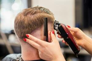 girl hairdresser dries hair to a man in a salon photo
