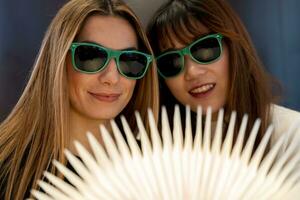 female couple of girlfriends are looking at a bright book photo