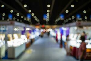 Blurred images of trade fairs in the big hall. image of people walking on a trade fair exhibition or expo where business people show innovation activity and present products in a big hall. photo