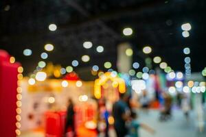 Blurred images of trade fairs in the big hall. image of people walking on a trade fair exhibition or expo where business people show innovation activity and present products in a big hall. photo