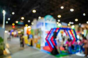 Blurred images of trade fairs in the big hall. image of people walking on a trade fair exhibition or expo where business people show innovation activity and present products in a big hall. photo