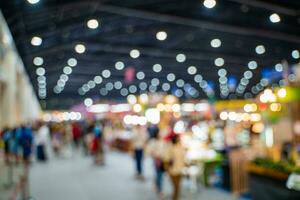 Blurred images of trade fairs in the big hall. image of people walking on a trade fair exhibition or expo where business people show innovation activity and present products in a big hall. photo