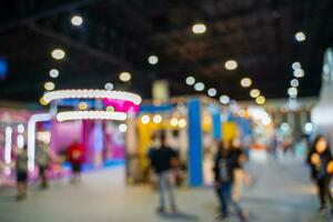 Blurred images of trade fairs in the big hall. image of people walking on a trade fair exhibition or expo where business people show innovation activity and present products in a big hall. photo