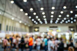 Blurred images of trade fairs in the big hall. image of people walking on a trade fair exhibition or expo where business people show innovation activity and present products in a big hall. photo