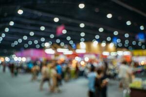 Blurred images of trade fairs in the big hall. image of people walking on a trade fair exhibition or expo where business people show innovation activity and present products in a big hall. photo