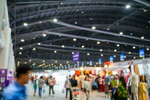 Blurred images of trade fairs in the big hall. image of people walking on a trade fair exhibition or expo where business people show innovation activity and present products in a big hall. photo