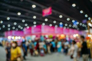 Blurred images of trade fairs in the big hall. image of people walking on a trade fair exhibition or expo where business people show innovation activity and present products in a big hall. photo