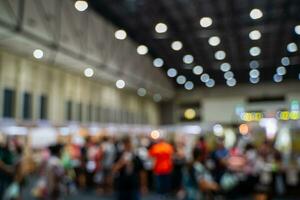 Blurred images of trade fairs in the big hall. image of people walking on a trade fair exhibition or expo where business people show innovation activity and present products in a big hall. photo