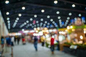 Blurred images of trade fairs in the big hall. image of people walking on a trade fair exhibition or expo where business people show innovation activity and present products in a big hall. photo