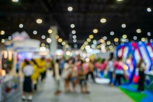 Blurred images of trade fairs in the big hall. image of people walking on a trade fair exhibition or expo where business people show innovation activity and present products in a big hall. photo