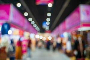 Blurred images of trade fairs in the big hall. image of people walking on a trade fair exhibition or expo where business people show innovation activity and present products in a big hall. photo