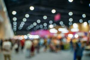 Blurred images of trade fairs in the big hall. image of people walking on a trade fair exhibition or expo where business people show innovation activity and present products in a big hall. photo