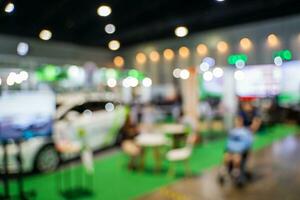 Blurred images of trade fairs in the big hall. image of people walking on a trade fair exhibition or expo where business people show innovation activity and present products in a big hall. photo