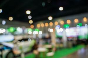 Blurred images of trade fairs in the big hall. image of people walking on a trade fair exhibition or expo where business people show innovation activity and present products in a big hall. photo